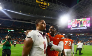 Image via Athlon Sports. As Virginia Tech QB Kyron Drones looks on in shock, his cousin, Miami QB Cam Ward, flexes his bragging rights in the family rivalry.